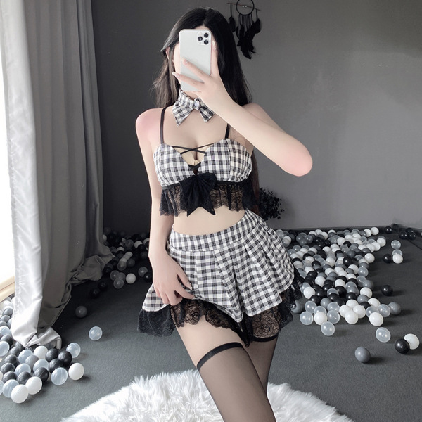 Woman in qingruohan checkered lingerie set with bow, lace trim, and garter stockings, posing playfully on ball-filled floor.