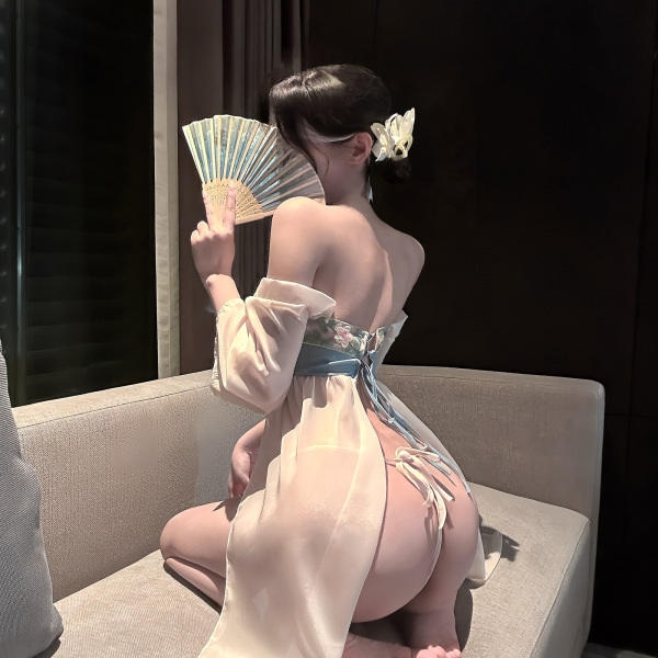 Woman wearing qingshe lingerie set, elegant chinese-inspired sexy sweet underwear, holding a fan, sitting on a couch.