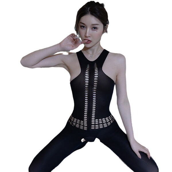 Woman wearing black sheer bodysuit with lace trim and open-crotch design, posing confidently.