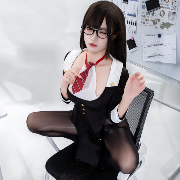 A stylish individual wearing a chic black and white dress with a red tie, posing confidently indoors.