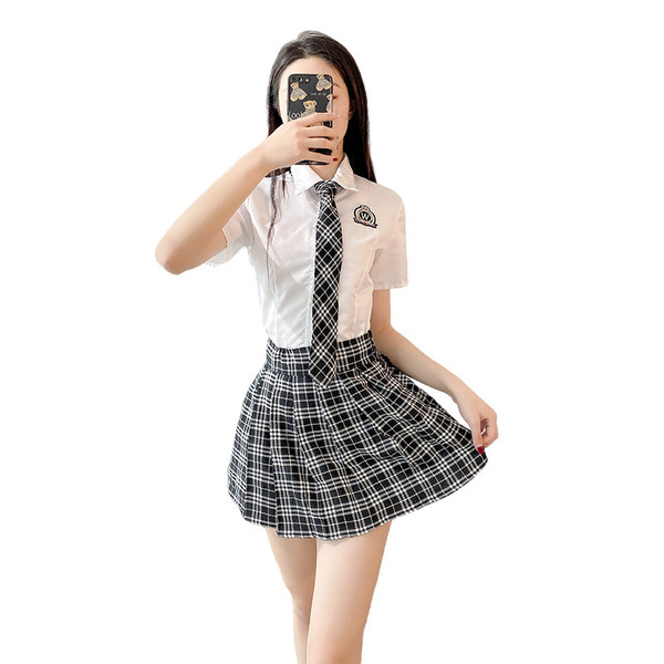 A woman models a stylish school uniform outfit featuring a white blouse with a tie and a black-and-white plaid skirt, perfect...