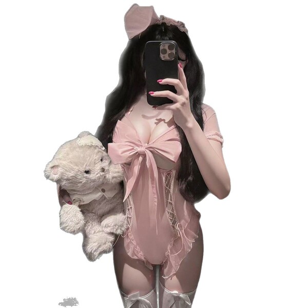 Woman in pink rabbit girl costume set with chest cutout, holding teddy bear and taking mirror selfie. sexy lingerie bodysuit ...