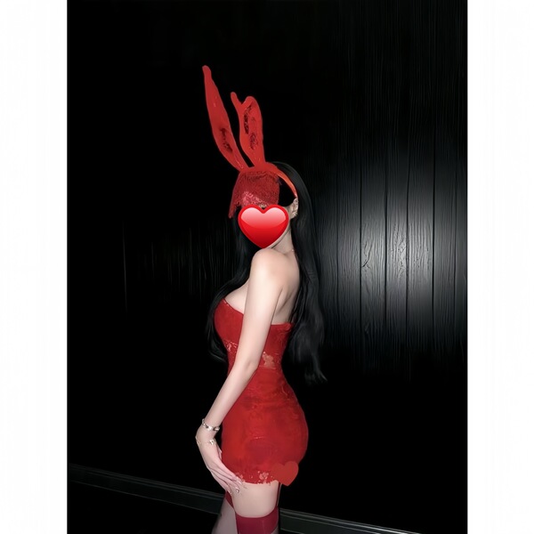 Woman wearing red bunny lingerie set with lace crop top, mini dress, and ears for christmas or cosplay.