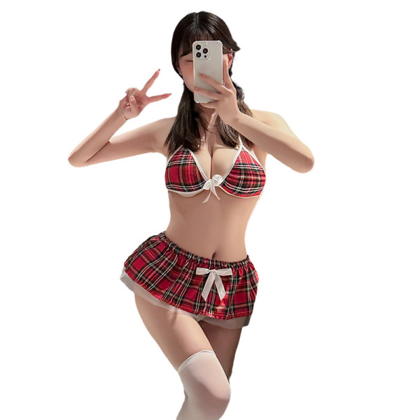 Woman modeling red plaid schoolgirl mini skirt set with matching bralette and white thigh-highs, holding phone for selfie.
