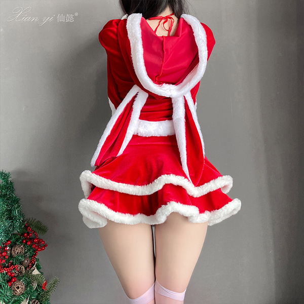 Woman wearing red velvet christmas-themed lingerie set with white fur trim, featuring a short skirt and playful design.