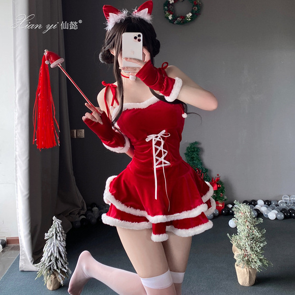 A woman poses in a festive red velvet christmas outfit featuring a short skirt, cat ears, and gloves, perfect for holiday cel...