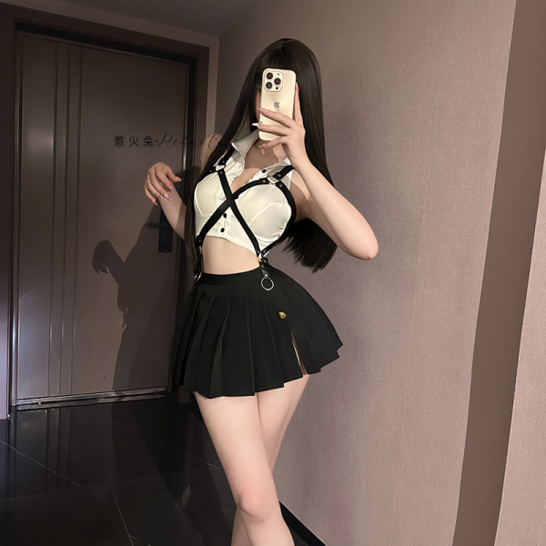 Woman wearing a white and black sailor-themed lingerie set with suspenders, taking a mirror selfie in a bedroom setting.