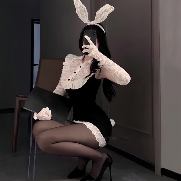 Woman in black secretary bunny girl lingerie set with lace gloves, ears, and heels posing seductively for role play.