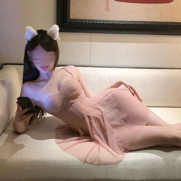 Woman lounging on a sofa wearing a seductive lace mesh slip dress set, featuring a provocative design for plus size women.
