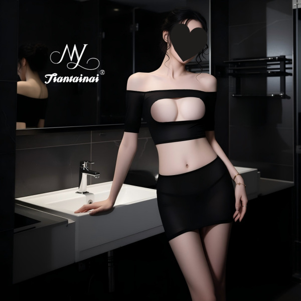Woman in black seductive lace peek-a-boo two-piece sleepwear set with low-cut bra and matching shorts, posing by sink.
