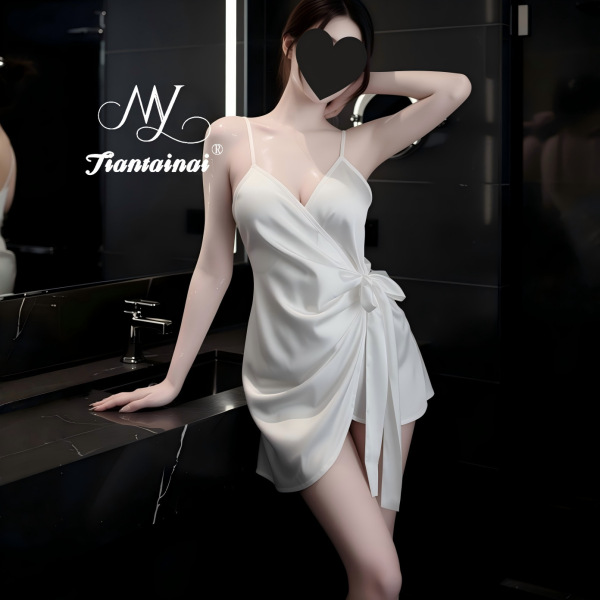 Woman in elegant white satin cami dress with wrap tie, posing in modern bathroom – seductive lace sleepwear for women