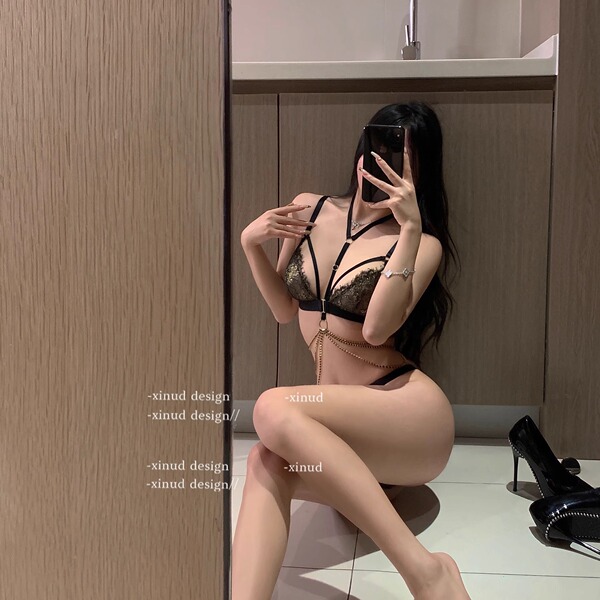 Woman modeling seductive lace tie-back bikini set in mirror selfie, showcasing premium sensual lingerie with elegant design.