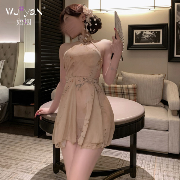 Woman in beige floral qipao lingerie set with sheer fabric, posing elegantly in a luxurious bedroom setting.