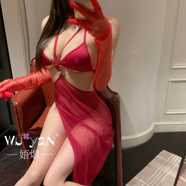 Woman wearing red seductive no-remove lingerie set with sheer gloves, posing in a stylish room.
