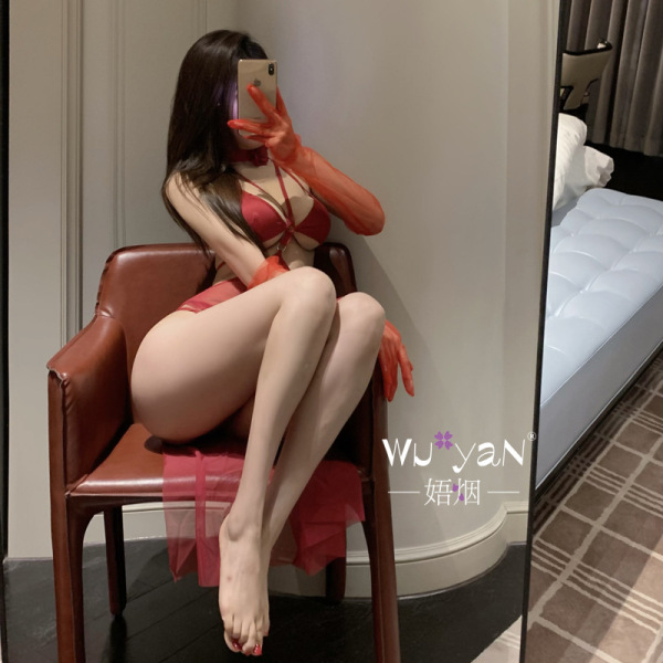 Woman in red seductive no-remove lingerie set posing on chair, pure & tempting sleepwear with sheer gloves and stockings.