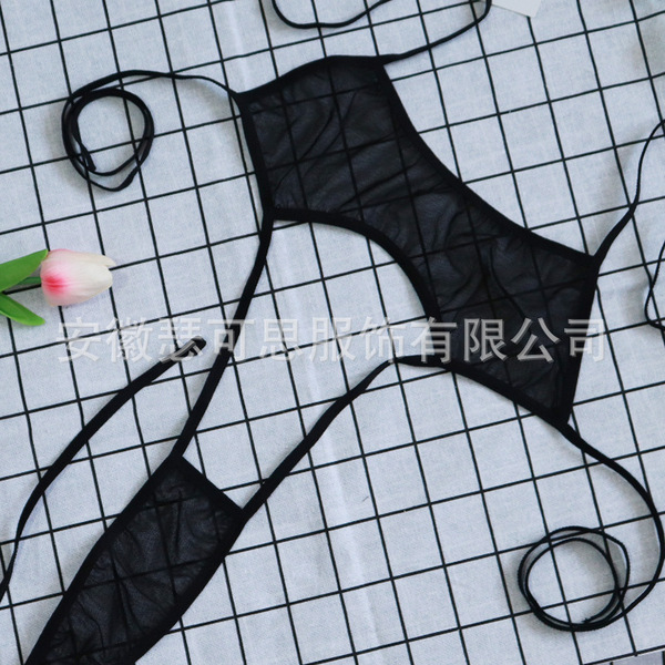 Sheer black mesh lace sleepwear set with delicate ties, displayed on a grid background alongside a soft pink tulip.