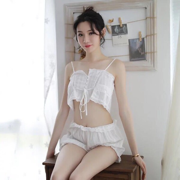 Woman wearing white lace bodysuit and backless camisole set, elegant sleepwear ensemble with delicate detailing.