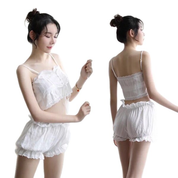 Woman modeling white lace bodysuit and backless camisole set, elegant sleepwear ensemble with ruffled shorts for sophisticate...