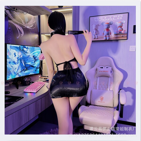 A woman stands facing a computer setup, wearing a black corset-style top with an embroidered design. the scene features gamin...