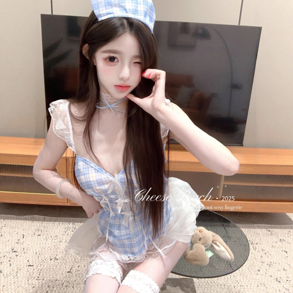 Model wearing blue plaid maid outfit with deep v lace top, sheer mini skirt, and matching headpiece.
