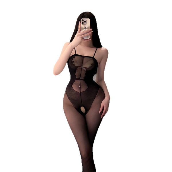 Woman wearing a black sheer mesh bodystocking with an open-crotch design, taking a mirror selfie.