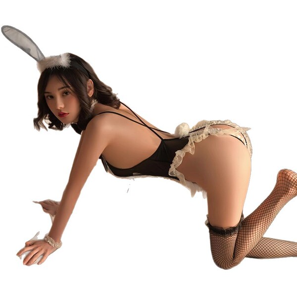 Woman in black bunny girl bodysuit with sheer mesh, open-crotch design, fishnet stockings, and fluffy ears — sexy lingerie co...