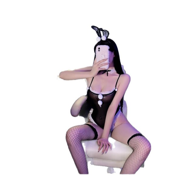 Woman in black bunny girl lingerie set with open-crotch bodysuit, fishnet stockings, and bunny ears headband.