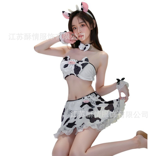 Woman modeling sexy cow print lingerie set with playful open-crotch skirt, matching bra, and cute horn headband for bedroom f...