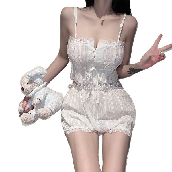 Woman modeling white sheer lingerie set with lace trim, holding teddy bear and making peace sign.