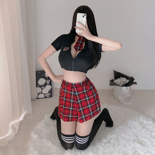 Woman modeling sexy jk style lingerie set with red plaid skirt, black crop top, and striped socks on white rug.