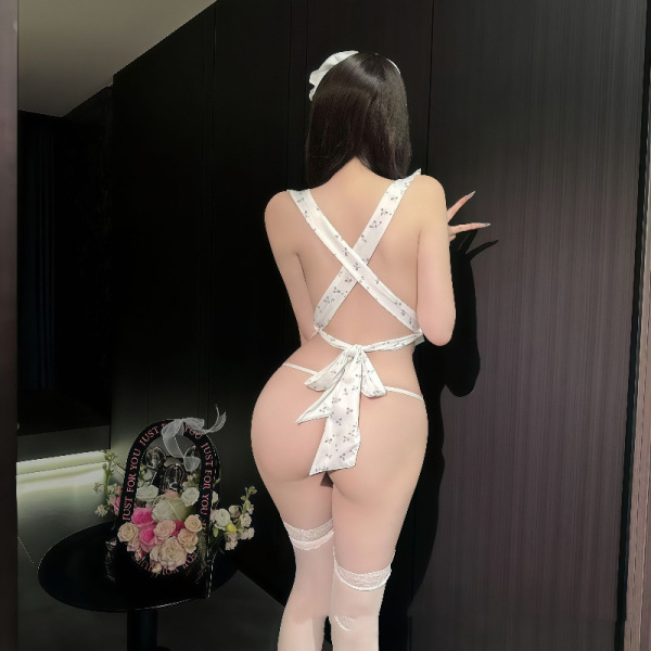 Woman wearing sexy lace backless maid costume with sheer apron, bare-back design, cheeky cutout, and white thigh-high stockin...