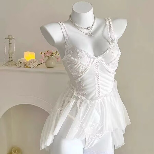 White lace cami nightgown with sheer mesh, floral trim, and pearl straps on mannequin.
