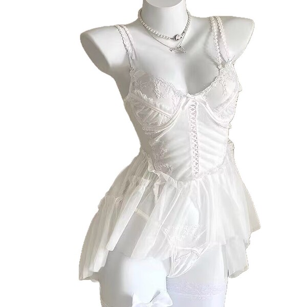 White lace cami nightgown with sheer mesh, floral trim, and corset-style bodice on mannequin.