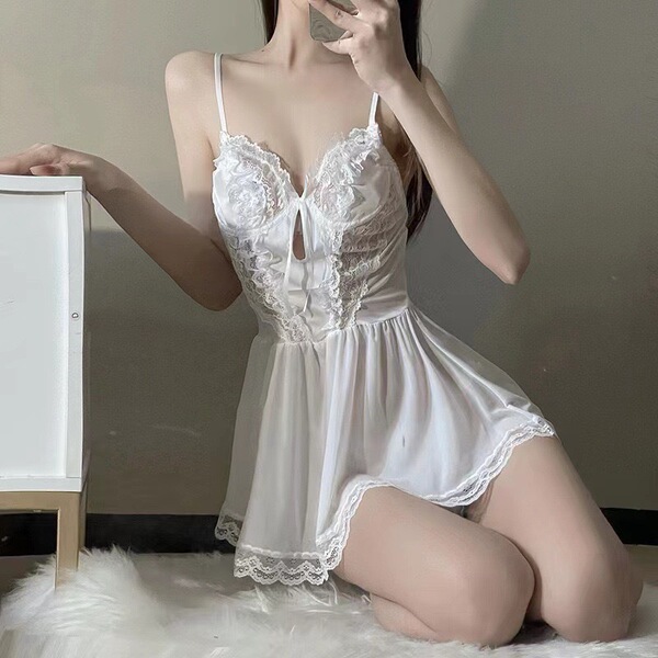 Woman kneeling in white lace sleepwear set with sheer skirt and floral details, showcasing seductive lingerie dress for bedro...