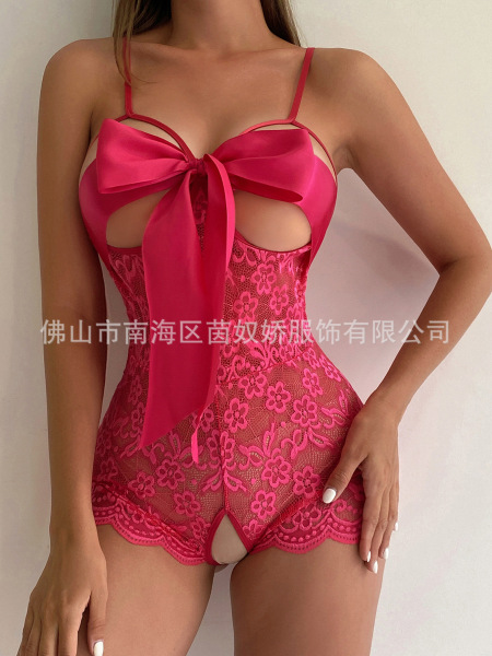 Woman wearing a hot pink lace teddy bodysuit with a large bow detail at the bust and sheer floral pattern.