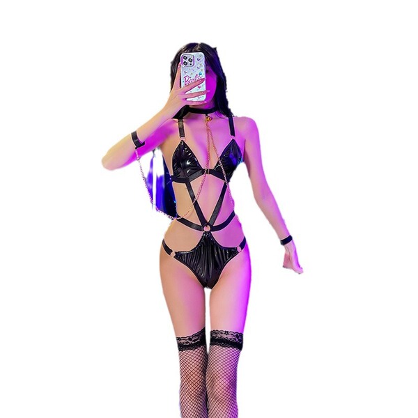 Woman wearing black leather maid costume with bondage straps, fishnet stockings, and choker for bdsm cosplay or lingerie role...
