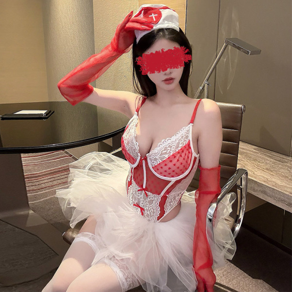 Woman in red and white lacy nurse costume with tulle skirt, posing for role play or cosplay.
