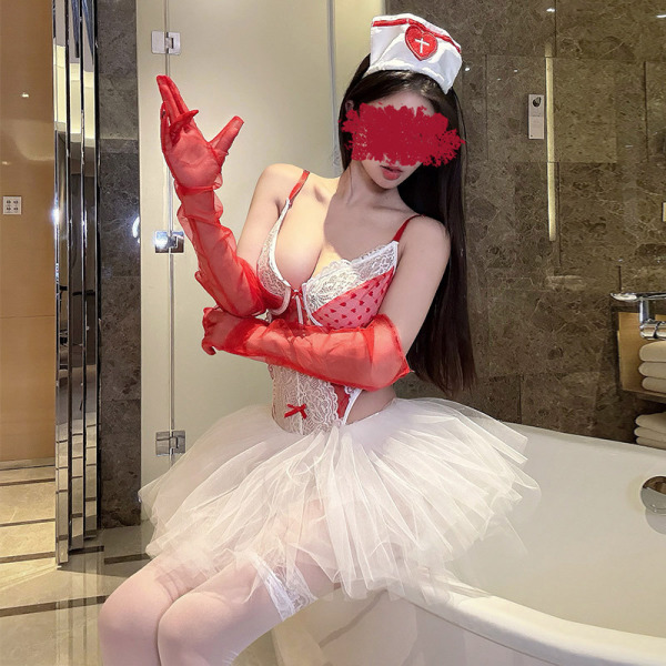 Woman in sexy nurse costume with lace bodice, red gloves, white tutu skirt, and nurse hat for halloween or cosplay.