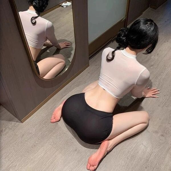Woman in sexy ol secretary costume lingerie set - provocative bodycon sleepwear for women, posing on floor with mirror reflec...