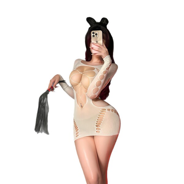 Woman in sexy ripped sheer mesh bodysuit with provocative cut-outs, holding phone and tail accessory.