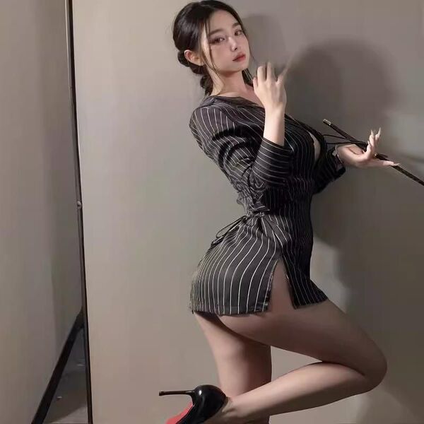 Woman wearing striped secretary costume with no-remove shirt and lingerie sleepwear, posing seductively in heels.