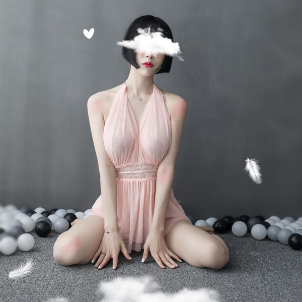 A woman sits gracefully wearing a sheer pink sleep dress with a deep v-neckline, perfect for lounging. the lace bodysuit feat...