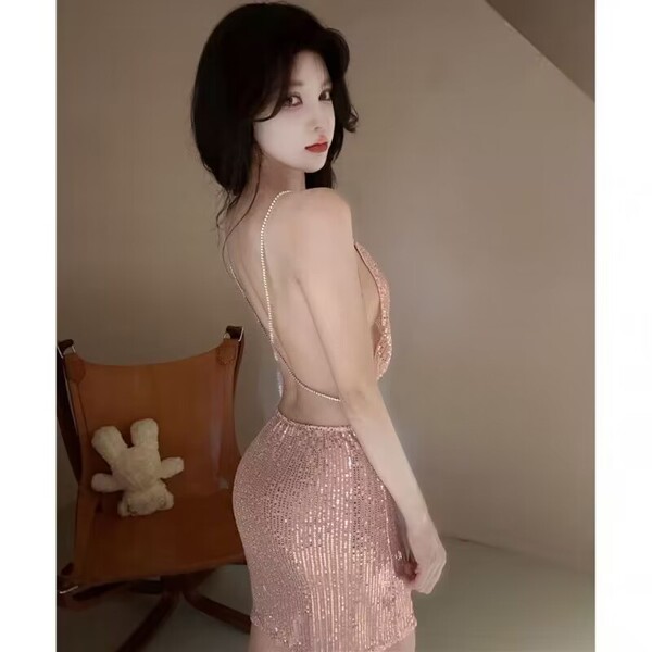 Woman wearing a shiny pink backless sleep dress with sheer detailing, perfect for nightlife or provocative loungewear.