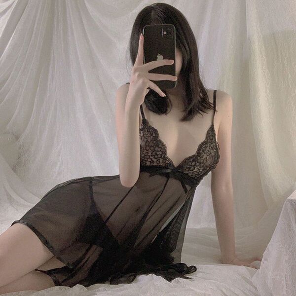 Woman in black lace cami and matching briefs, posing seductively on bed with sheer sleepwear set for intimate nights.