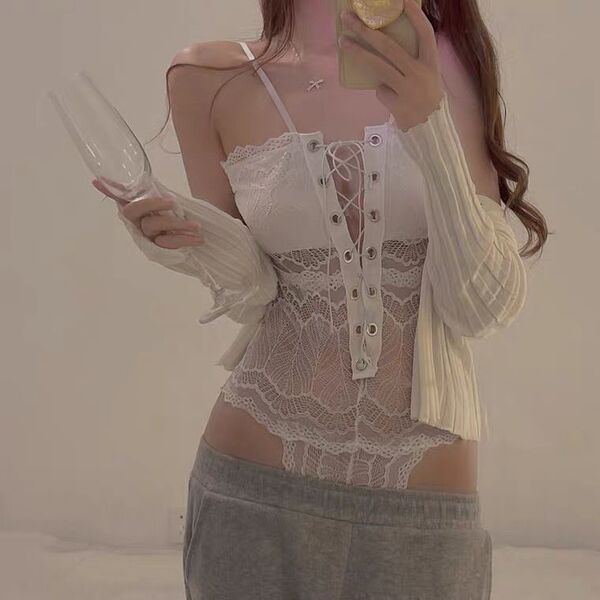 Woman wearing sexy transparent lace bodysuit with open-crotch design, paired with gray sweatpants and white cardigan.