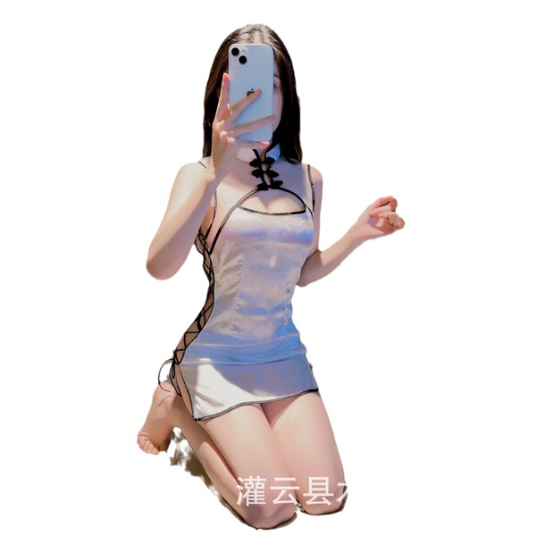 Woman kneeling in a white vintage qipao lingerie set with black side-tie details, taking a mirror selfie.