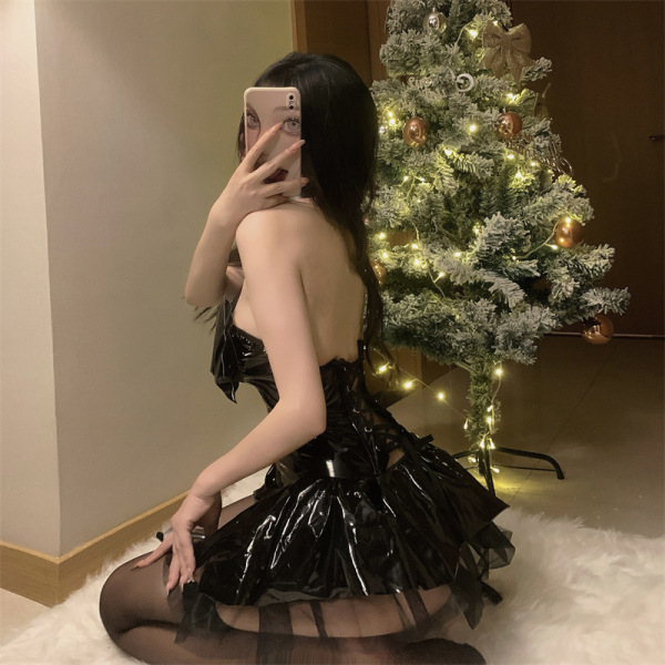 Woman wearing new shiny pu lace-up halter batwing halloween devil costume set with sheer mini skirt, posing by christmas tree...