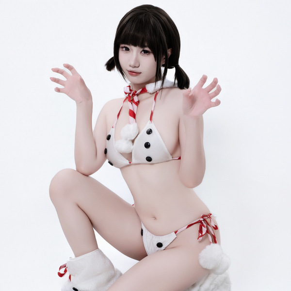 A woman poses wearing a white fuzzy christmas costume featuring a snowman-themed sexy lingerie bikini set with red accents an...
