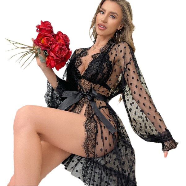 Woman in sheer polka dot robe and lace lingerie holding red roses.