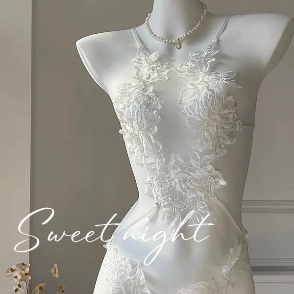 White sheer lace bodysuit with floral embroidery on mannequin, styled with pearl necklace for romantic bedroom wear.